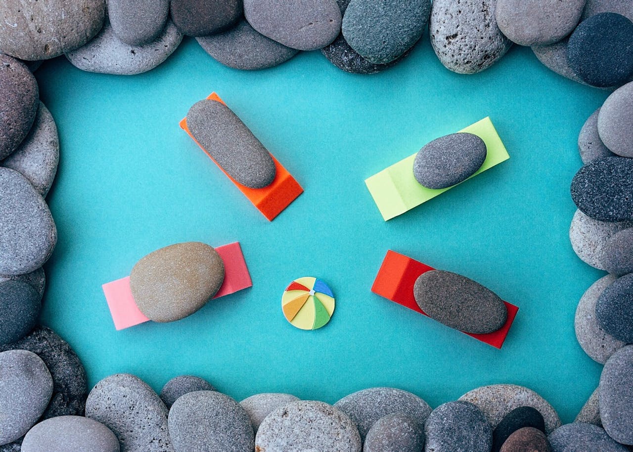 A collection of smooth stones arranged creatively on a colorful geometric background.
