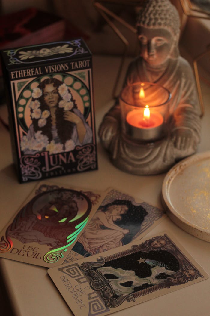 An enchanting tarot reading setup featuring Buddha statue, tarot cards, and candlelight ambiance.